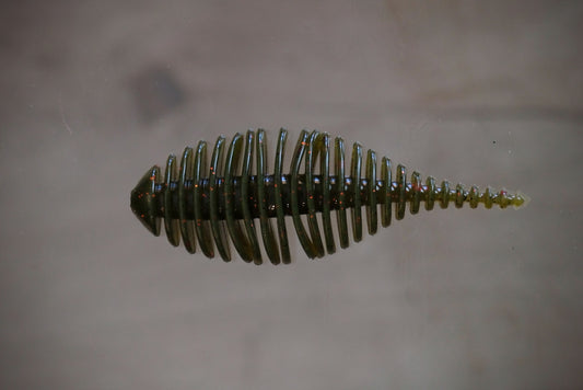 Watermelon with red and black flake fishing lure with a ribbed, segmented body and a tapered tail, shown against a neutral, light gray background.